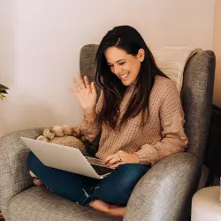 A woman happily meeting with her financial advisor on her laptop